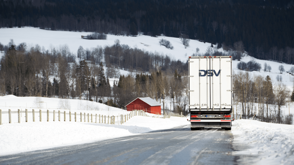 DSV-lastebil kjører på snødekt landevei.